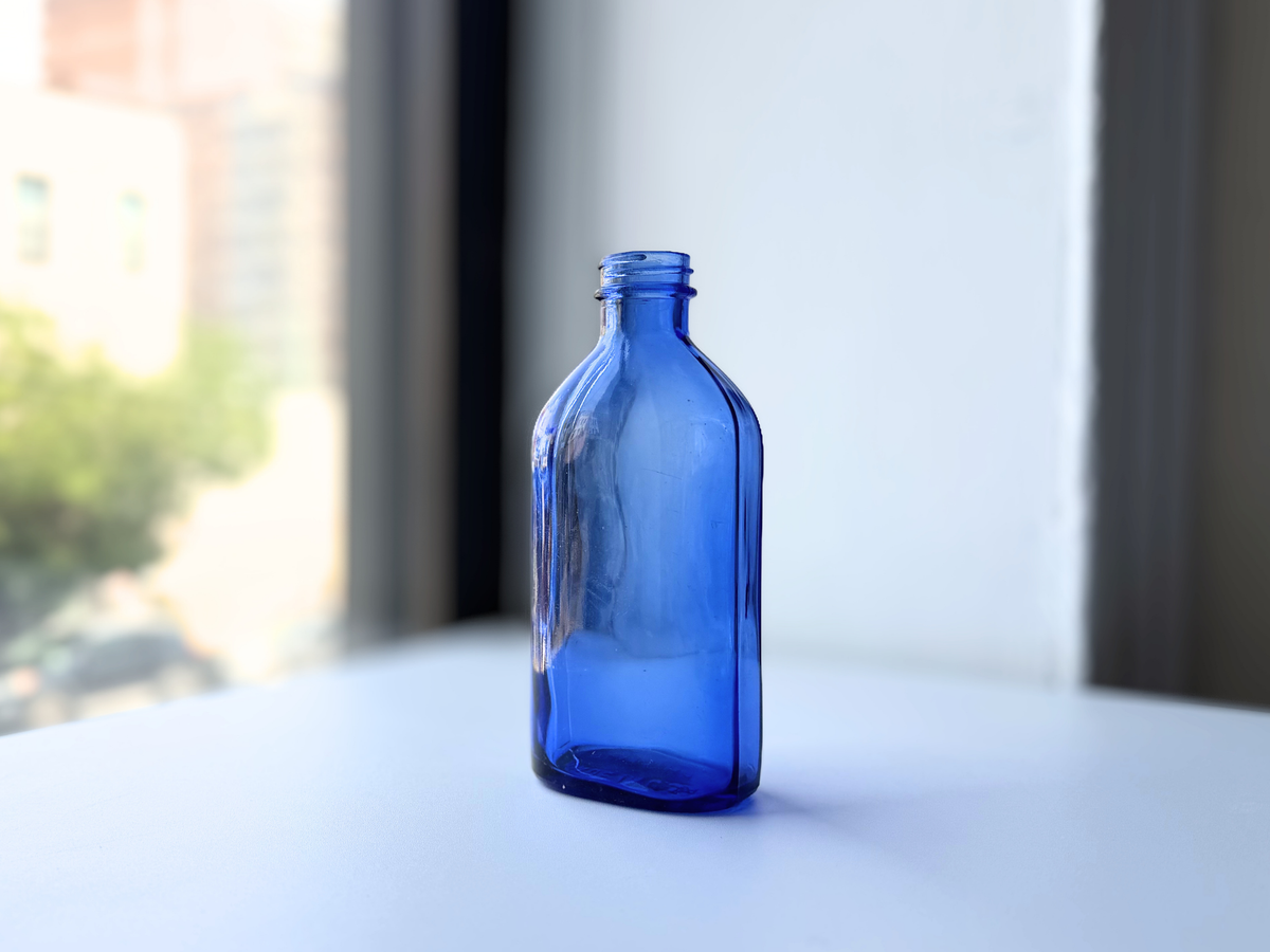 Phillips tall cobalt blue milk of magnesia bottle on windowsill, NYC beach recovery