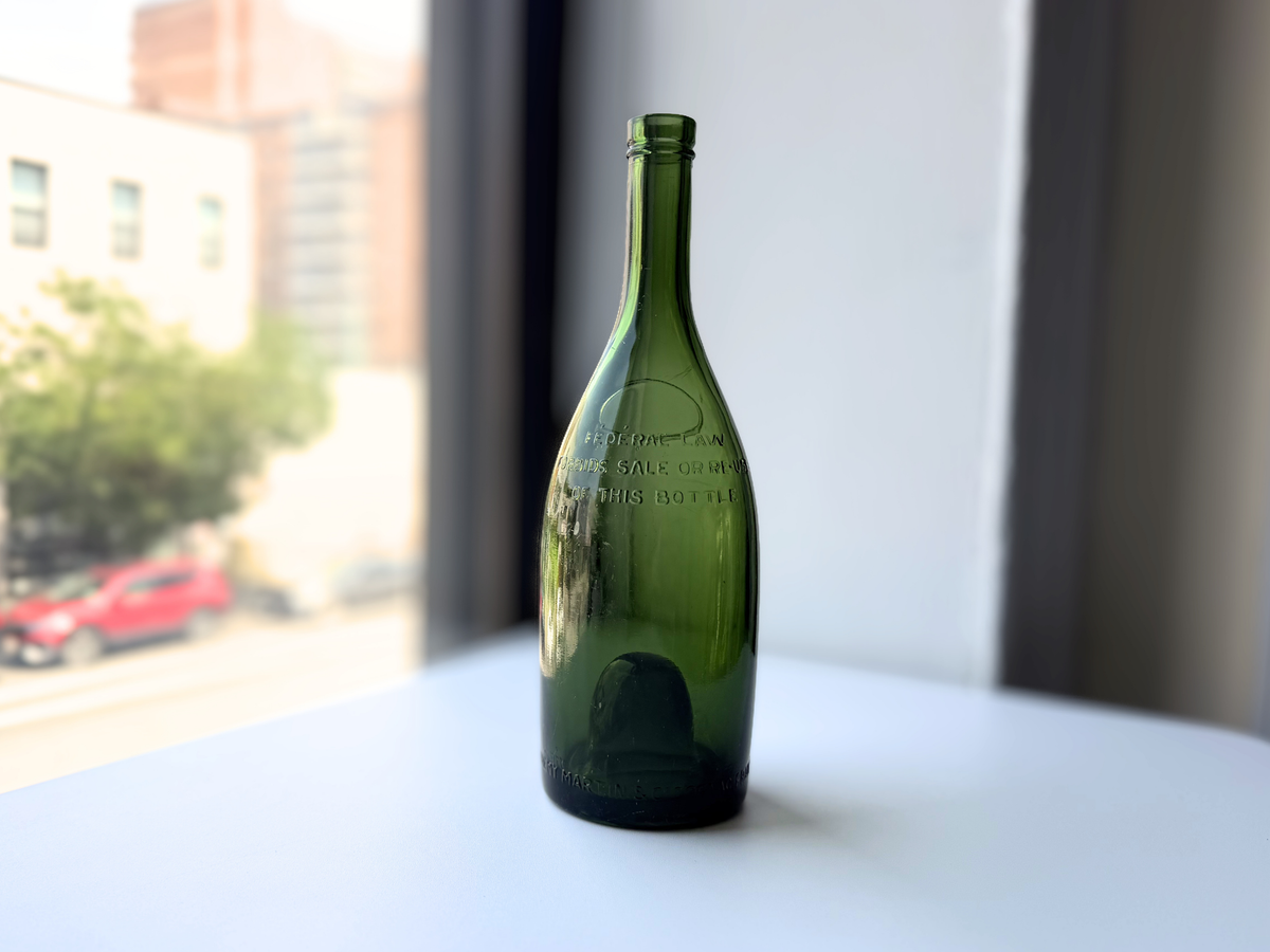 E. Remy Martin & Co green glass bottle displayed on a windowsill, made in France.