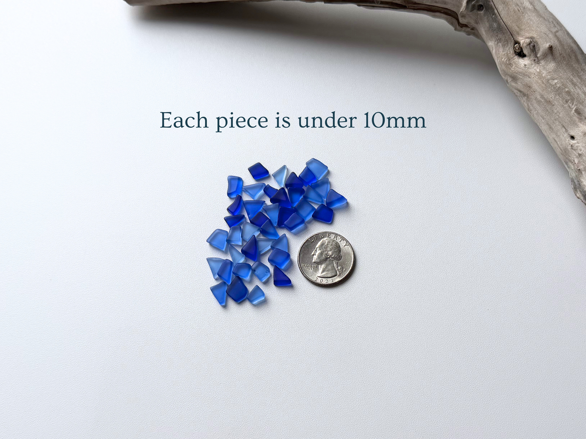 Small pile of deep blue micro sea glass beside a quarter, with text noting each piece is under 10mm.