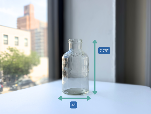 Vintage clear glass DAN-DEE jar shown against a window, full body view
