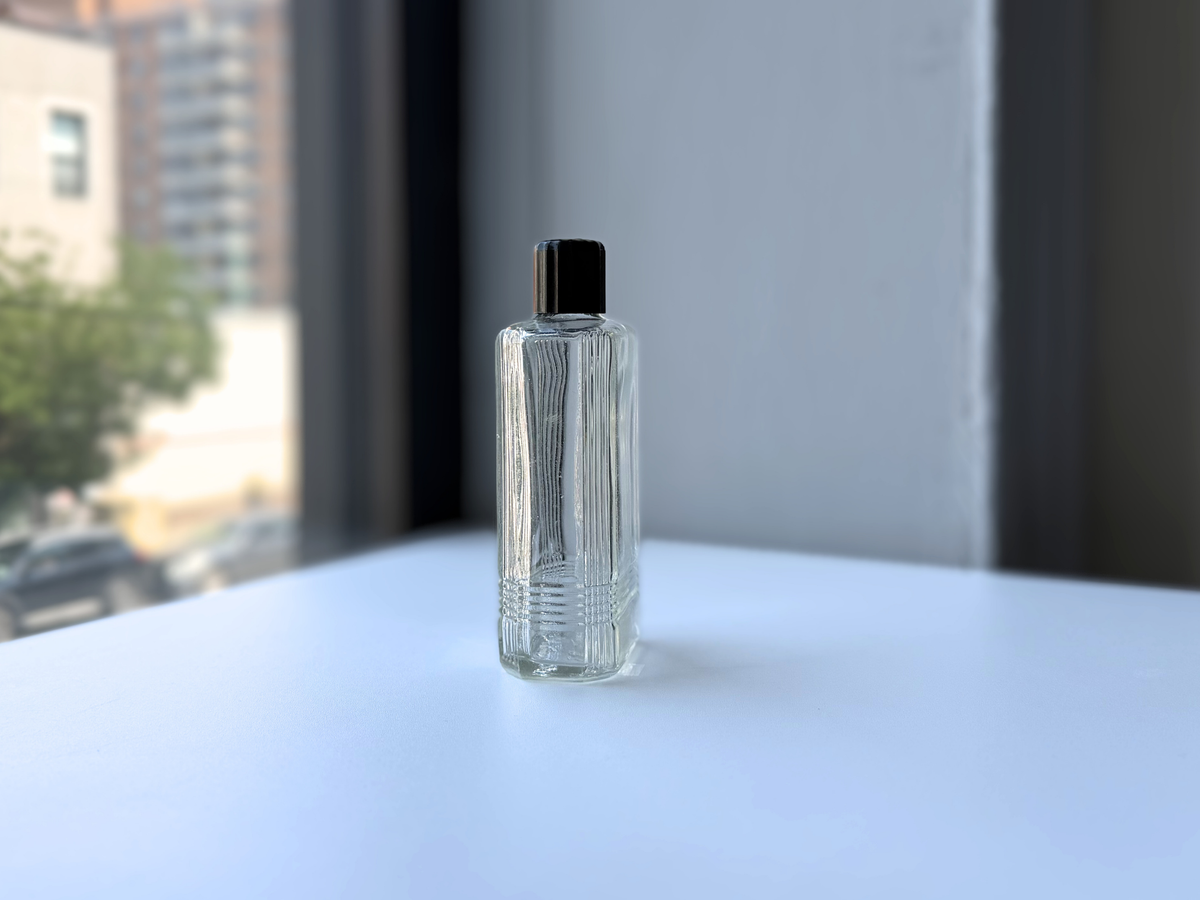 Mennen bottle 1952 clear glass front view, Art Deco stepped line pattern
