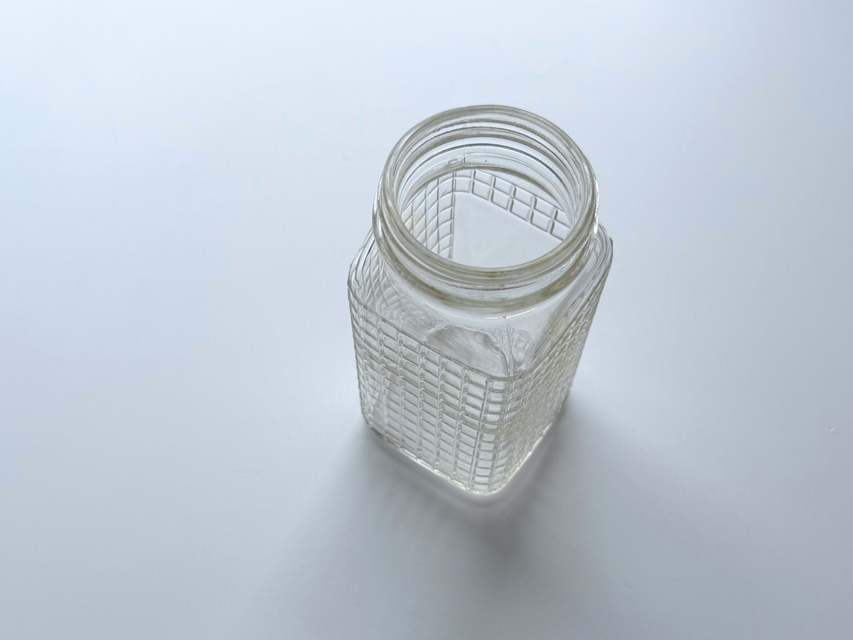 Top-down view into the open mouth of a Ball waffle glass jar.