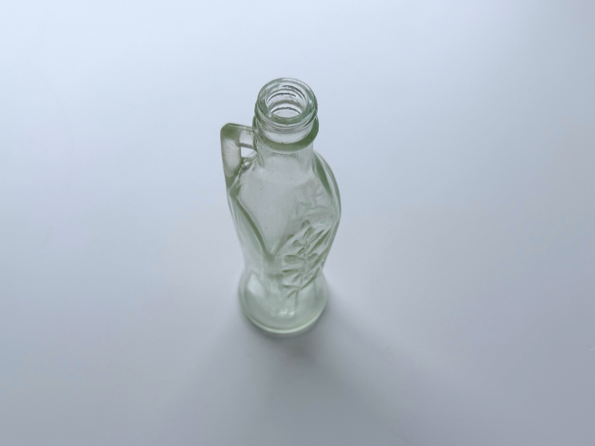 Bon Oil bottle with integrated glass handle, photographed on a gradient background.