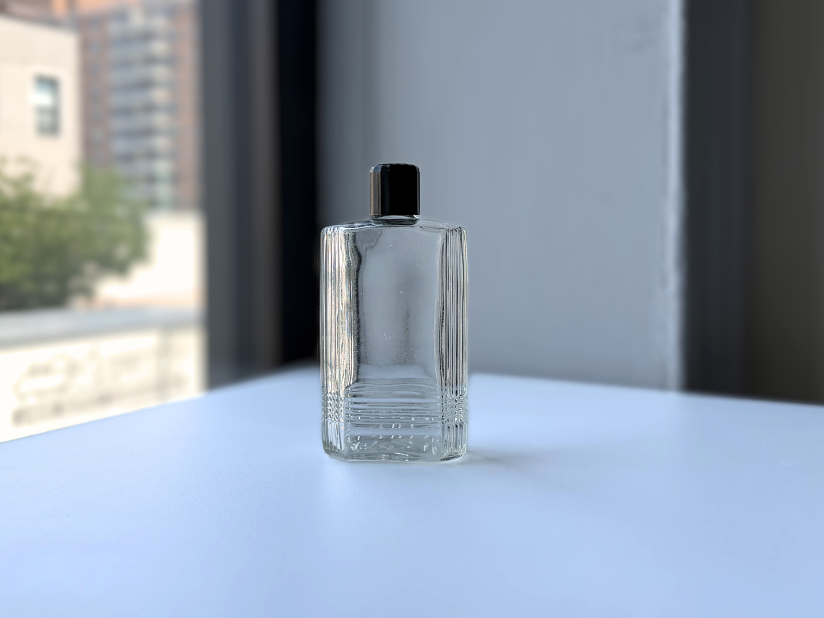 Mennen bottle in natural light showing clear glass and surface scratches