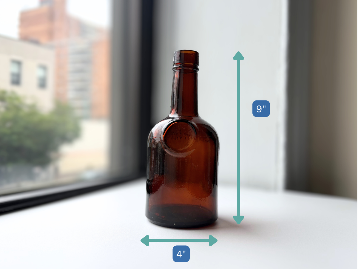 Dark amber glass bottle with height measurement overlay showing 9 inches tall.