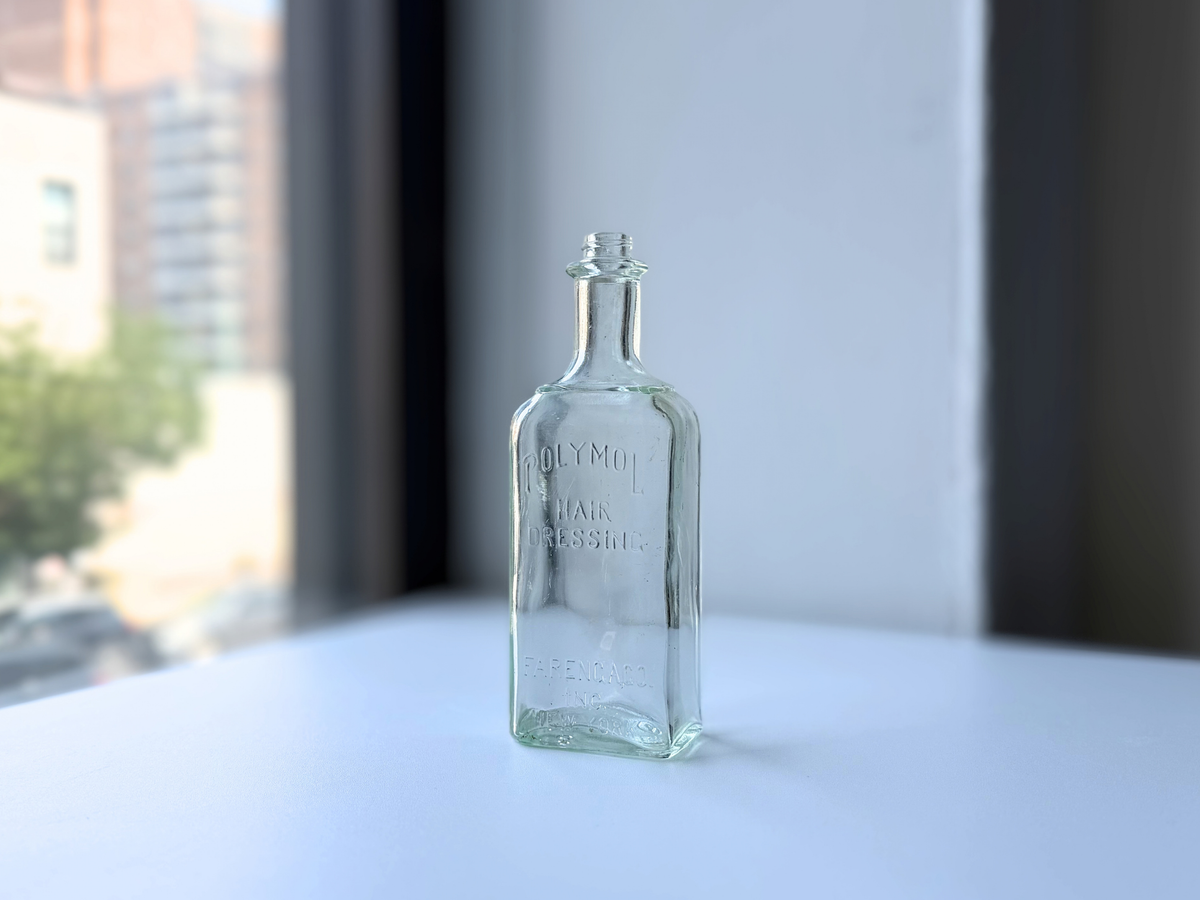 Front view of the Polymol Hair Dressing bottle with embossed Farenga Co New York lettering