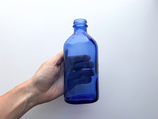 Hand holding extra large Phillips cobalt blue bottle for scale