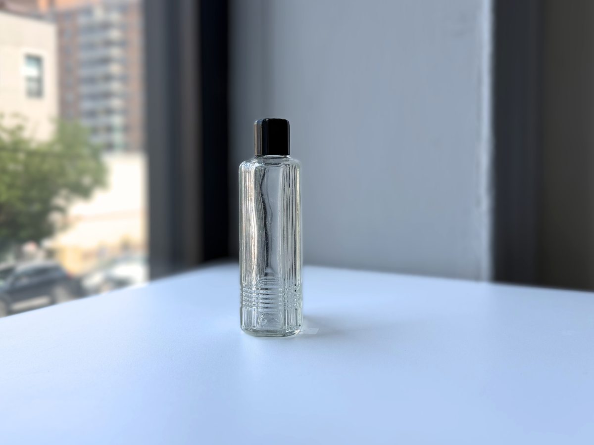 Mennen bottle three-quarter angled view, clear Art Deco glass grooming bottle