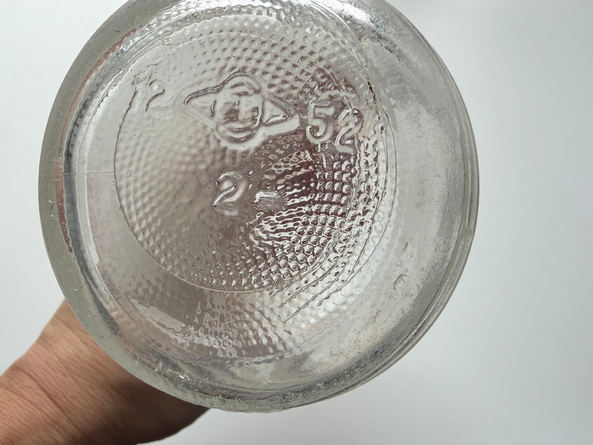 Close-up of the embossed base of a 1952 Lavoris bottle showing the date code and maker's mark.