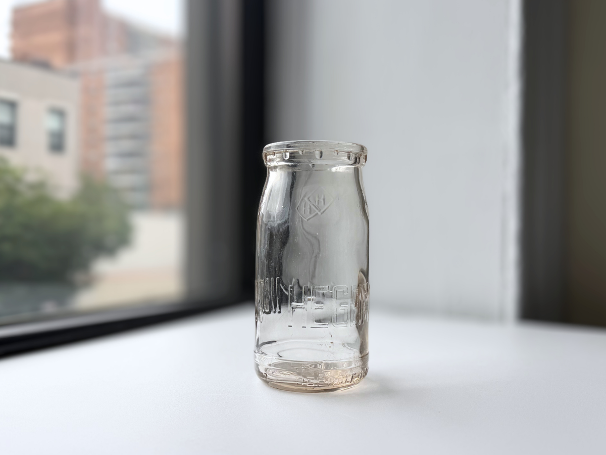 Hegeman Farms milk bottle on a windowsill at an angle.