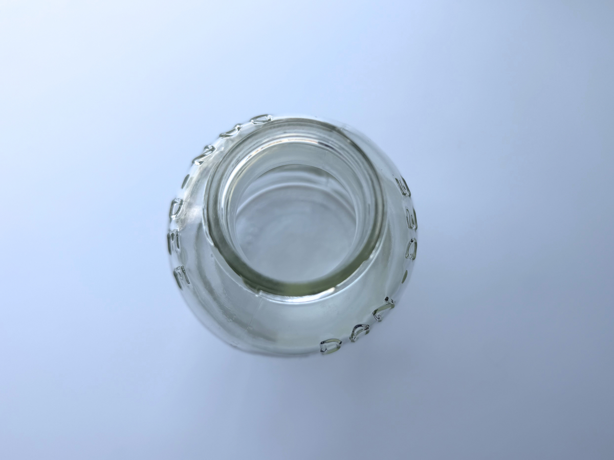 Overhead view looking down into the wide mouth opening of a vintage clear glass DAN-DEE jar