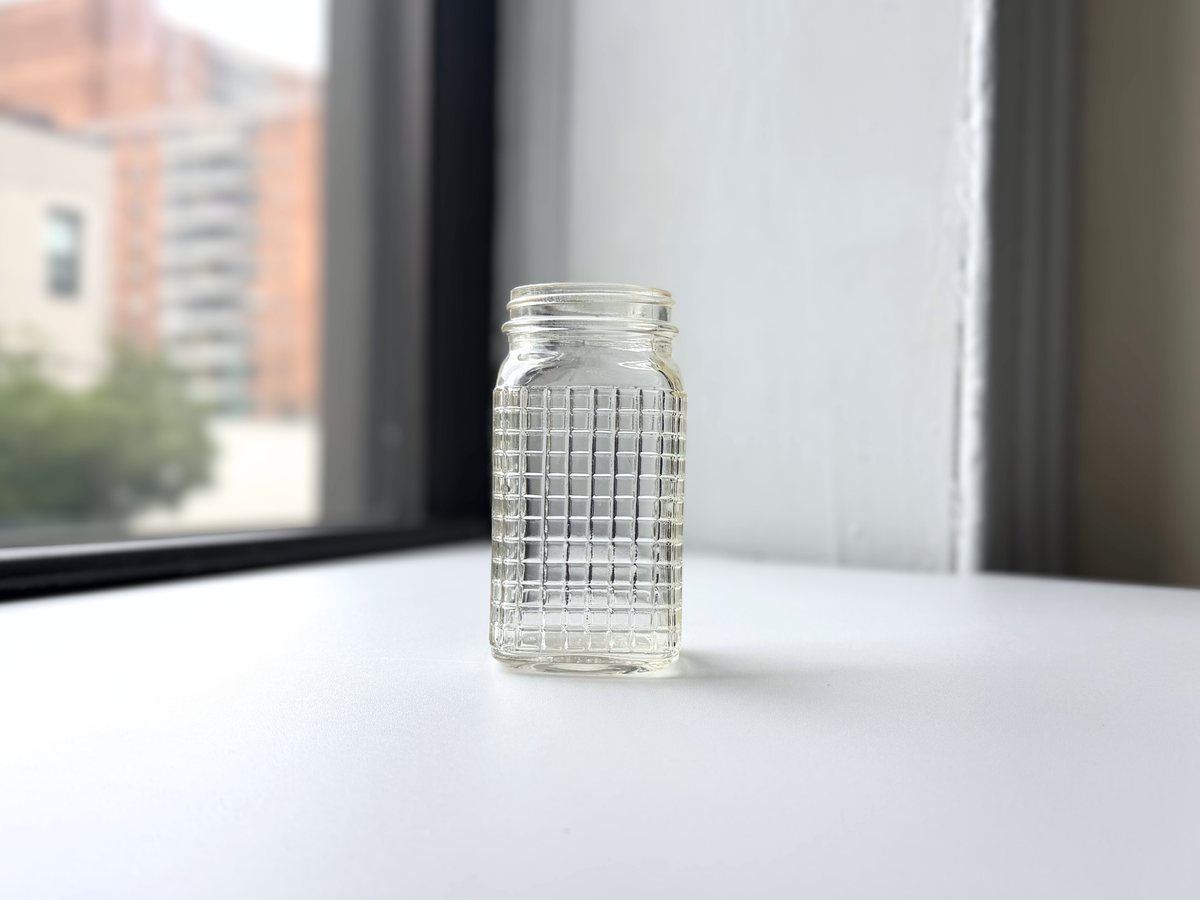 Ball waffle glass jar displayed on a windowsill with Brooklyn brownstones in the background.