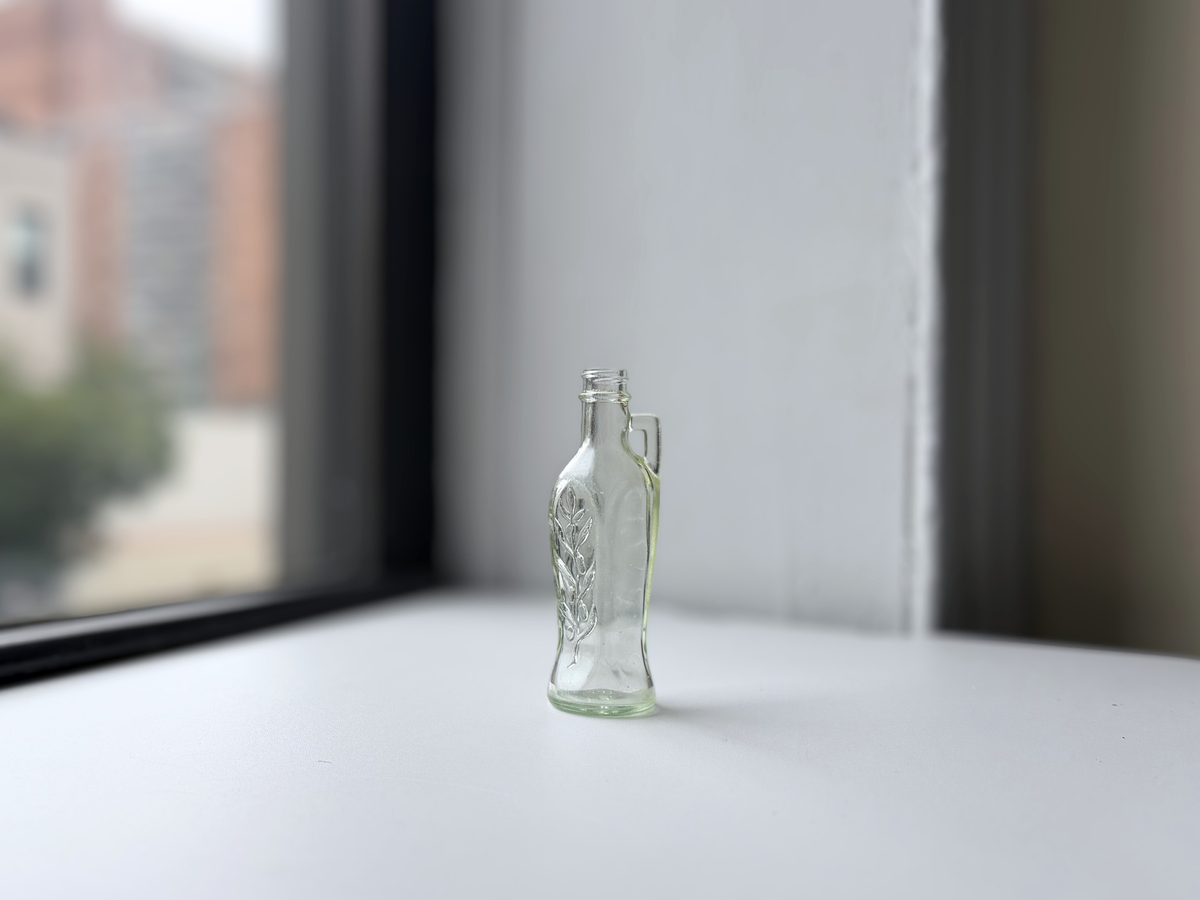 Bon Oil bottle displayed on a windowsill with Brooklyn brownstones in the background.