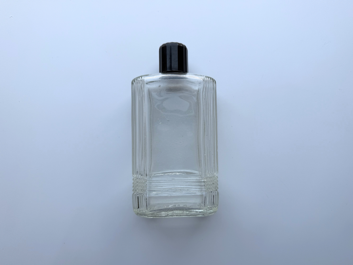 Mennen bottle with black cap product shot, clear Art Deco glass 1952