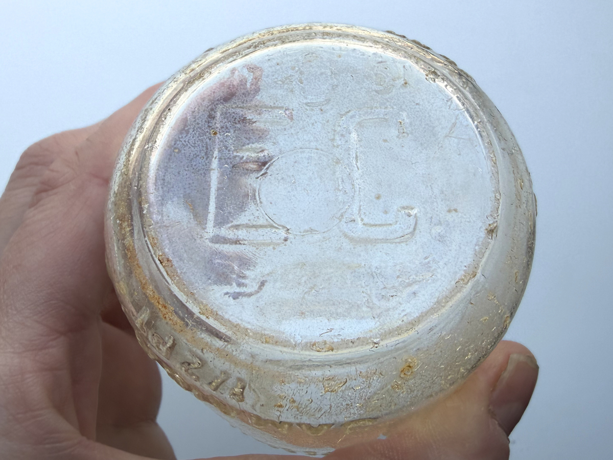 Close-up of bottle base in hand showing EC and 51 embossed marks dating the Elmhurst Cream Co bottle to 1951