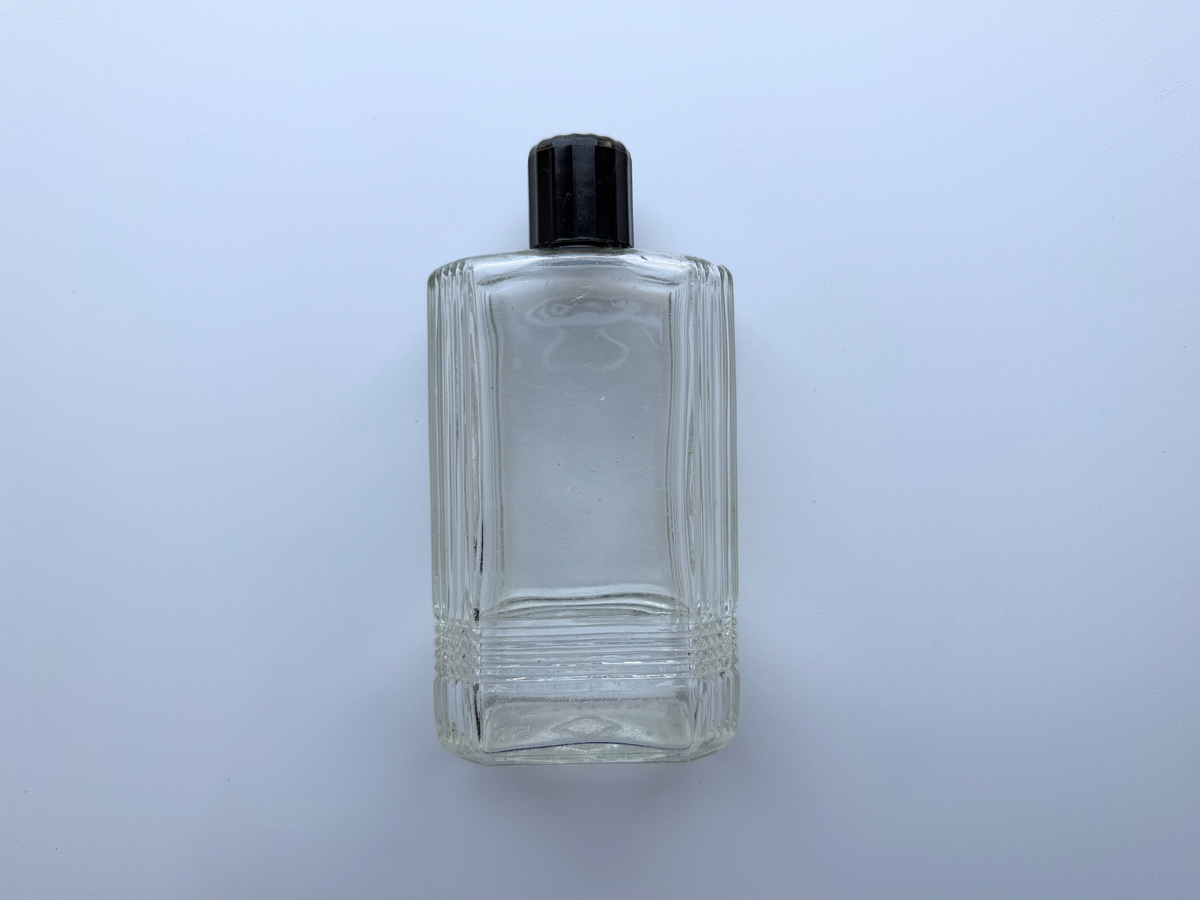Mennen bottle close view of Art Deco line pattern on clear glass
