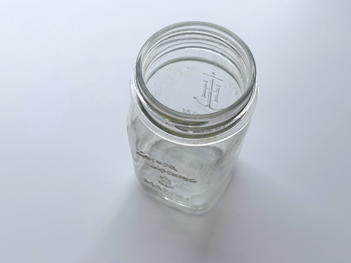 Top-down view into the open mouth of an Anchor Hocking mason jar.