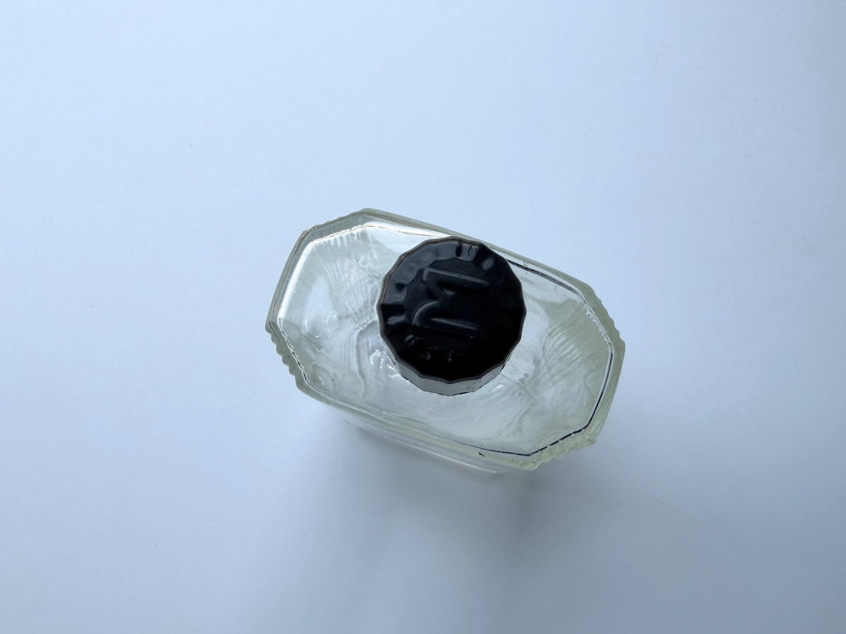 Mennen bottle black cap top view, clear Art Deco glass 1952