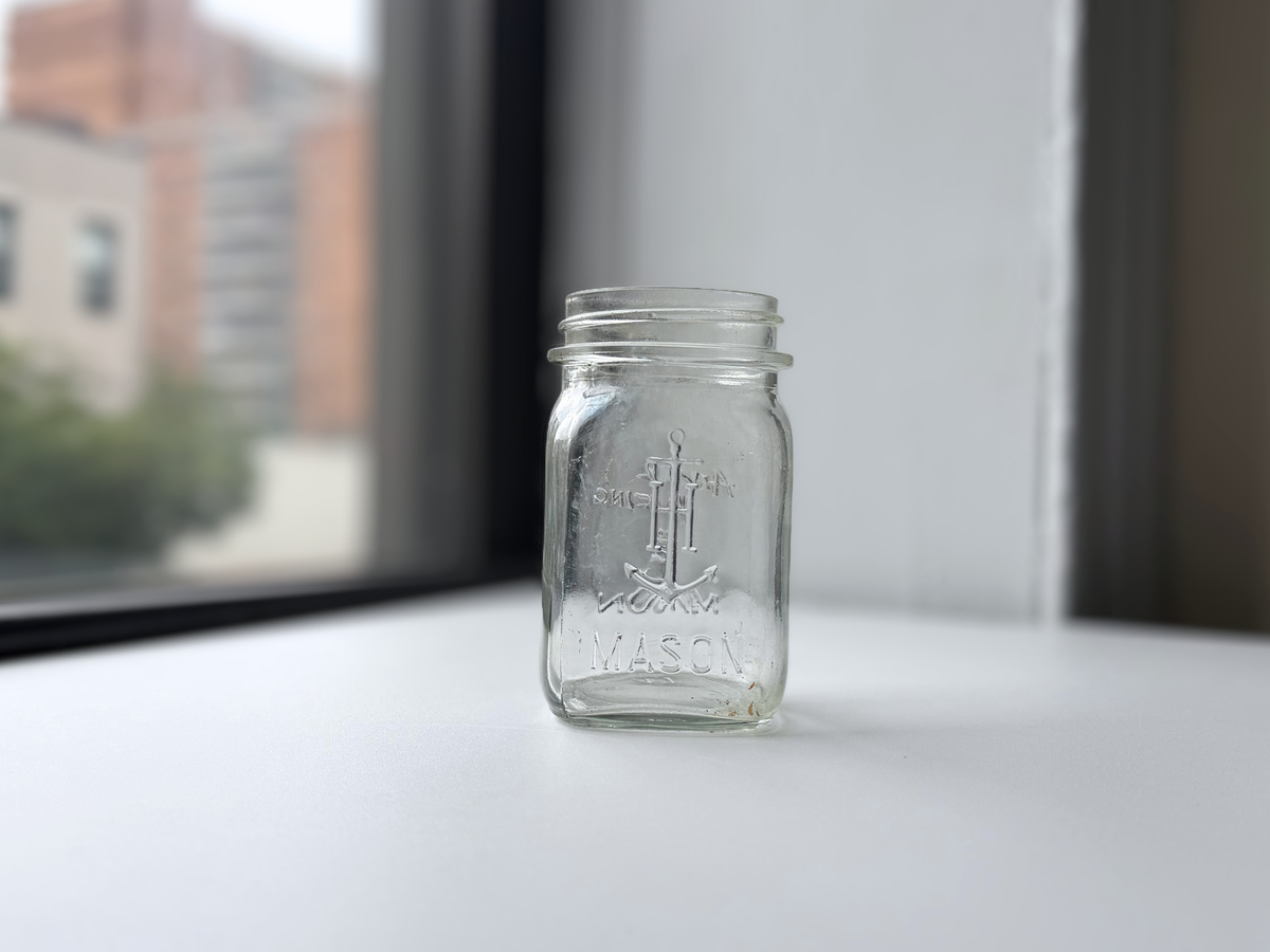 Anchor Hocking clear glass mason jar displayed on a windowsill, dated 1947.