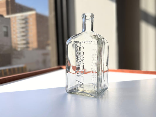 Vintage 1952 Cointreau clear glass liqueur flask 7.5 inches tall with COINTREAU and LIQUEUR embossing - French spirits collector piece hand-recovered from NYC, small chip on mouth
