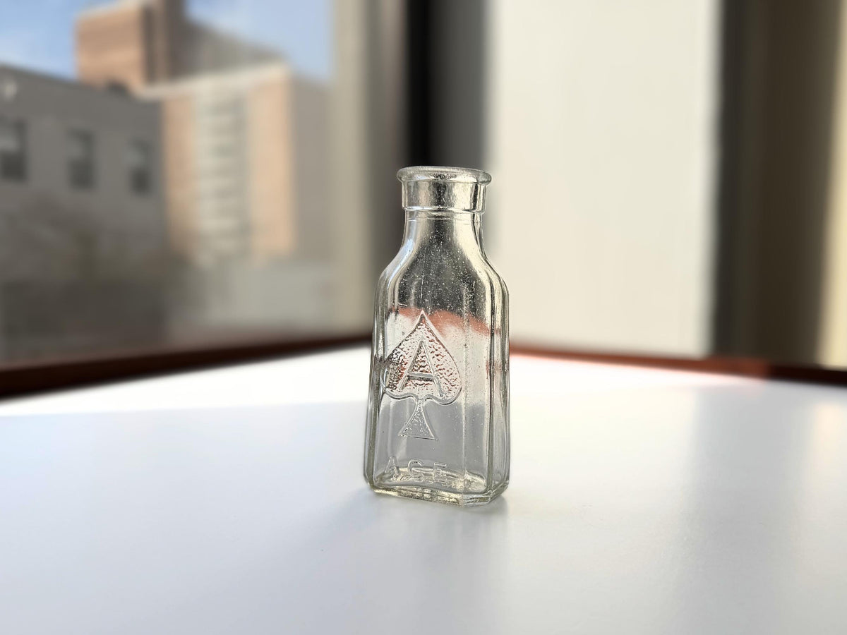 Ace Brand bottle angled view showing square profile with chamfered corners, mid-century clear glass