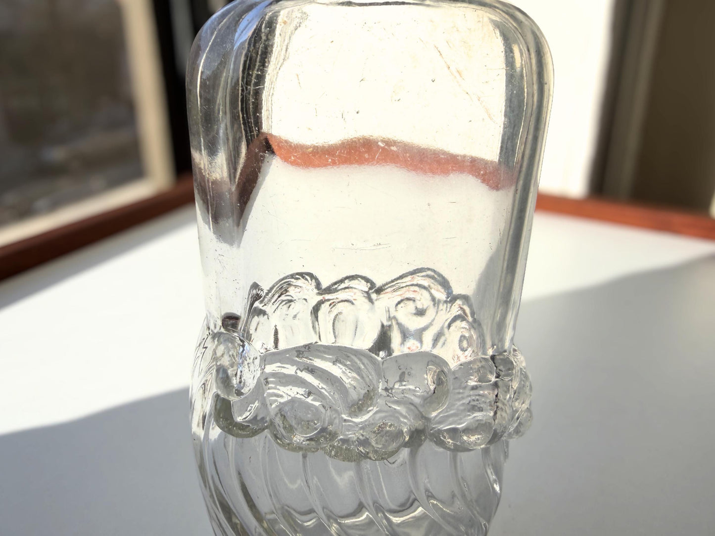 Vintage glass waves textured bottle with distinctive wavy pattern throughout. Clear glass with light patina. Perfect for vintage glass collectors and pattern enthusiasts.