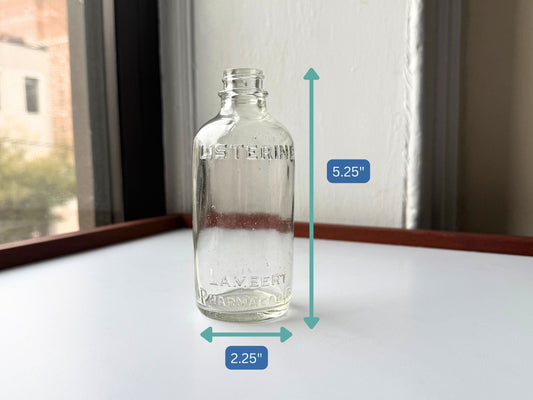 Elegant early 20th-century Listerine bottle from Lambert Pharmacal Co with embossed lettering and textured base perfect for vintage apothecary collectors pharmaceutical history displays bathroom shelf styling.