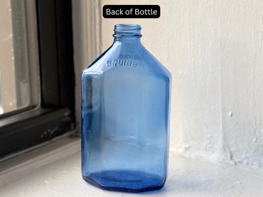 Back view of vintage Squibb cobalt blue medicine bottle featuring its embossed name and smooth rectangular contours – Brooklyn Sea Glass