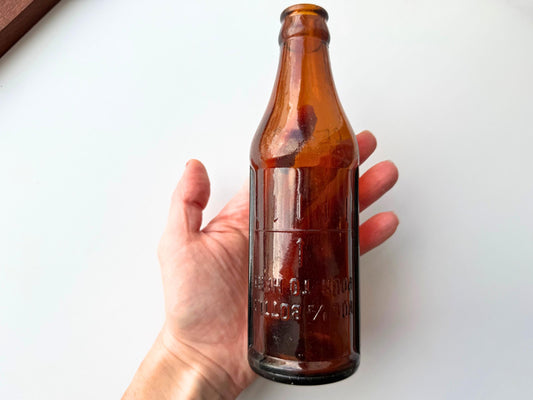 Certo bottle side view showing warm amber glass and inverted pour guide embossing on body