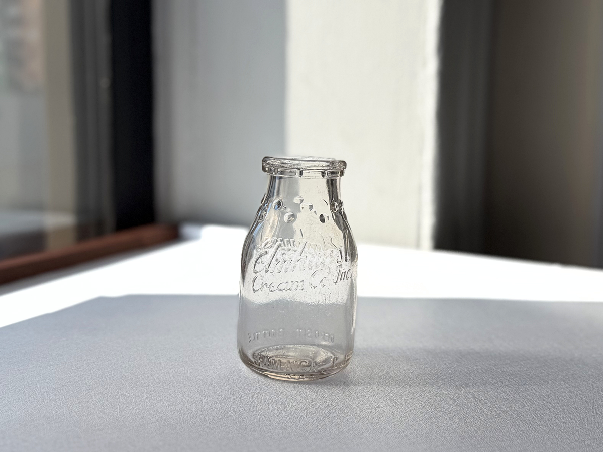 Elmhurst Cream Co. milk bottle with dimension overlay showing 4.75 inches tall by 2.5 inch diameter clear glass