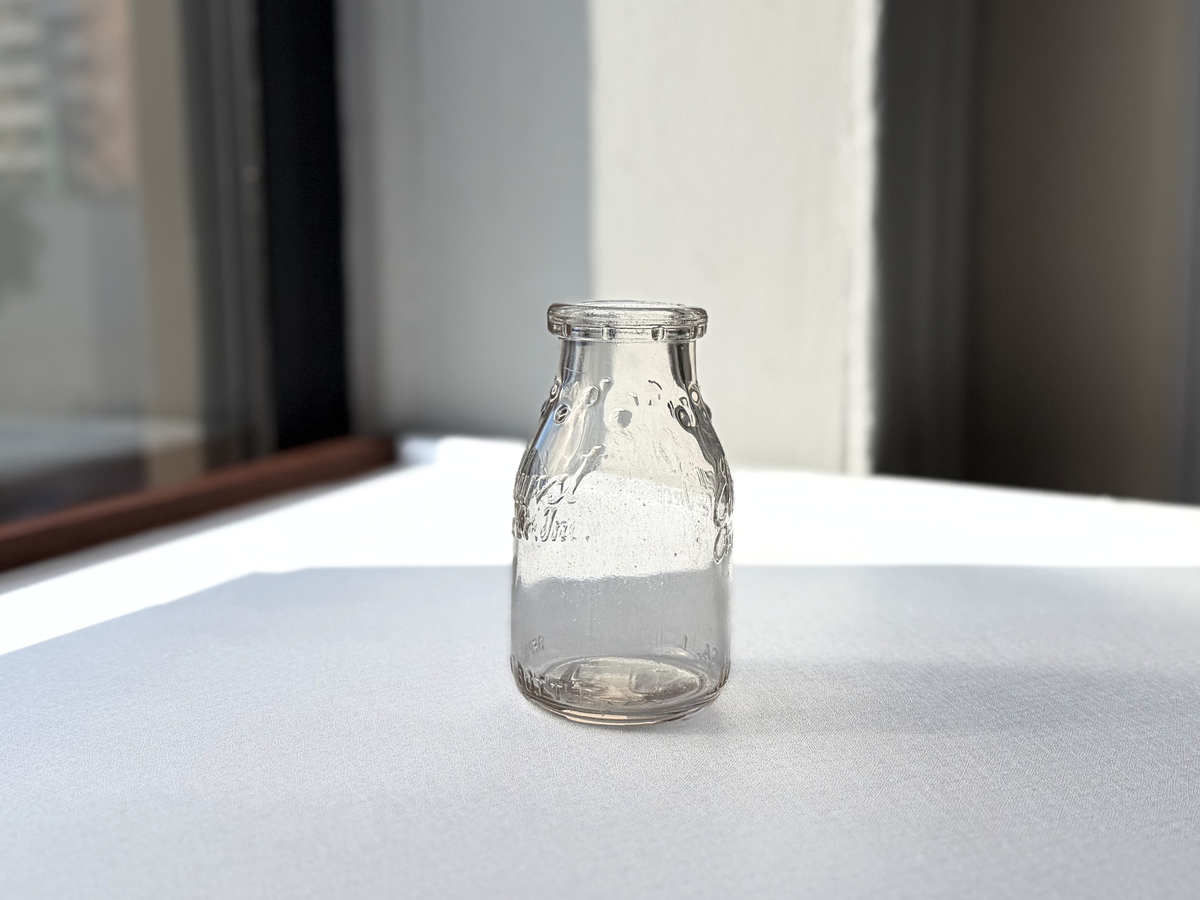 Elmhurst Cream Co. milk bottle full front view, clear glass half-pint with ELMHURST CREAM CO INC embossing, 4.75 inches