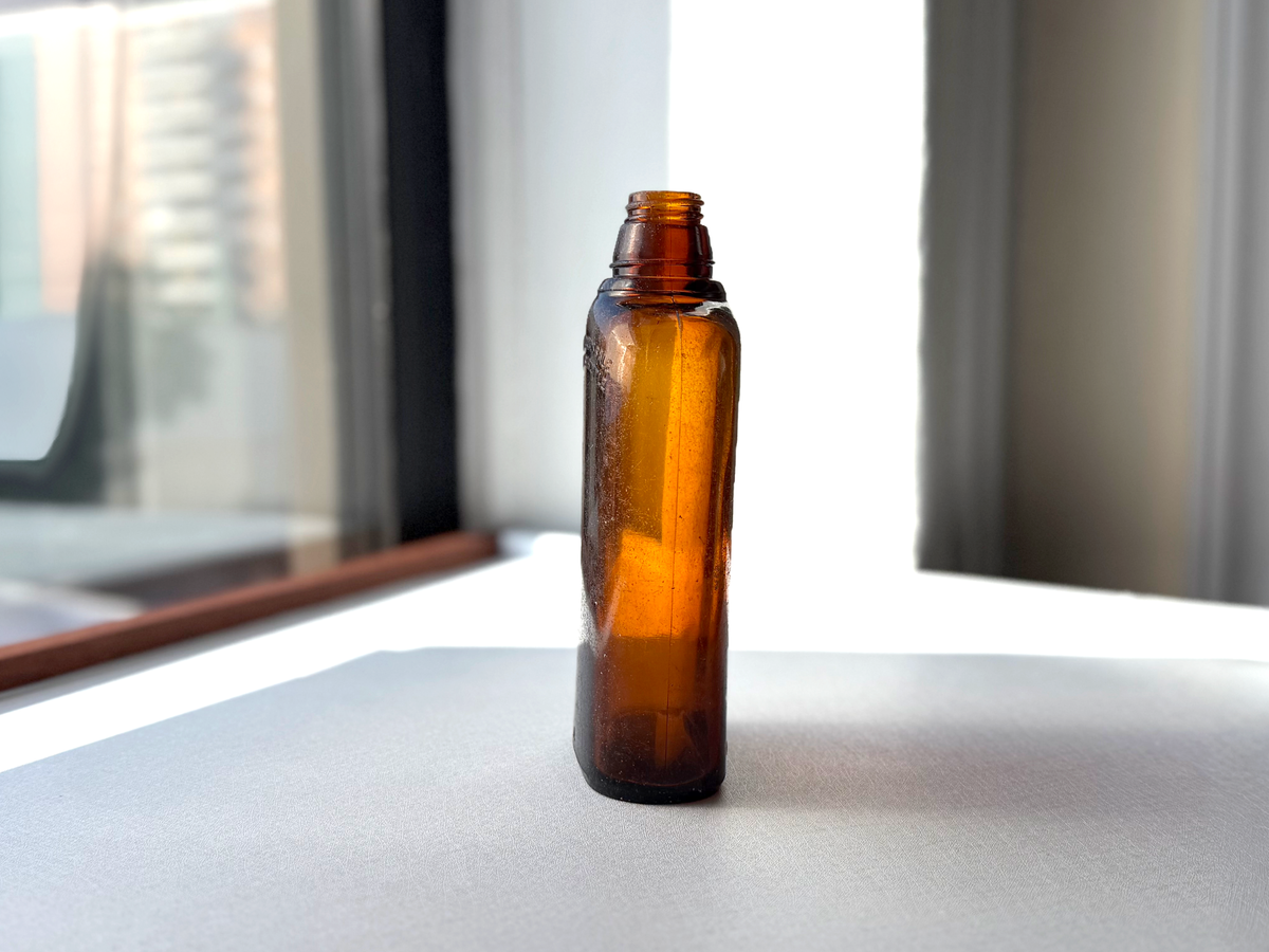 Federal Law wide-shoulder amber flask back view showing FEDERAL LAW FORBIDS SALE embossing on unbranded reverse face