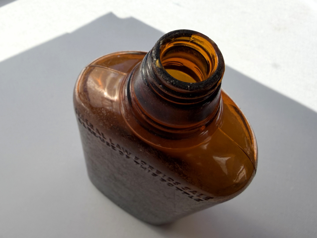 Federal Law wide-shoulder amber flask base showing production marks confirming approximately 1952 manufacture