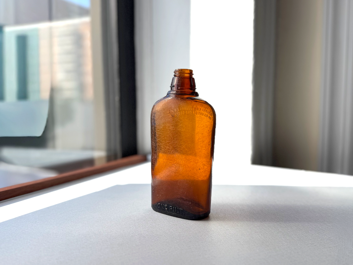 Federal Law 1952 wide-shoulder amber flask face-flat view showing exaggerated shoulder-to-waist taper profile