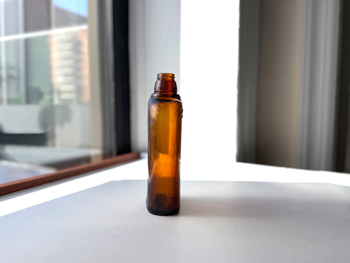 Federal Law 1952 wide-shoulder amber flask left side view showing flat-sided form and seaworn surface character