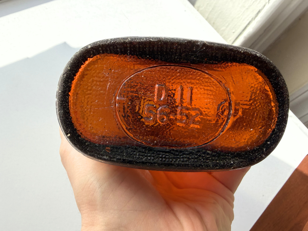 Federal Law wide-shoulder amber flask right side view showing narrow 2 inch depth and wide 3.75 inch shoulder