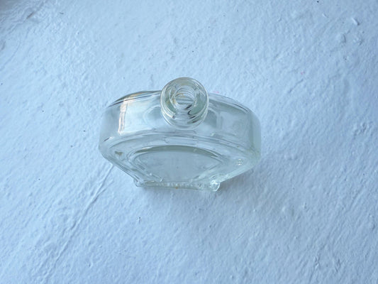 Another side angle of the clear glass bottle, emphasizing its smooth retro aesthetic.