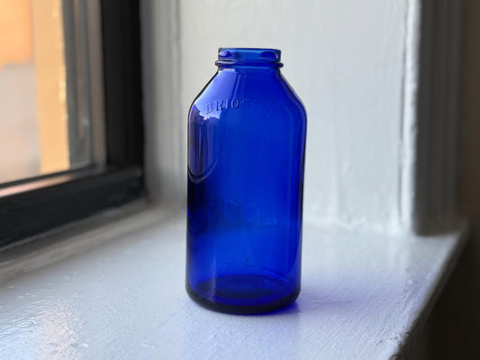 Frontal view of a vintage Brioschi cobalt blue glass bottle, highlighting its classic shape and bold blue color.