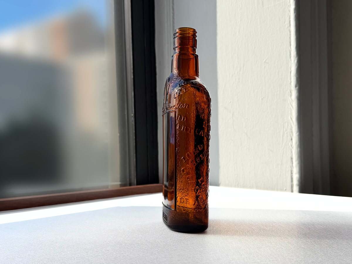 Lord Calvert 1952 amber whiskey flask angled right view, Men of Distinction vintage spirits bottle NYC