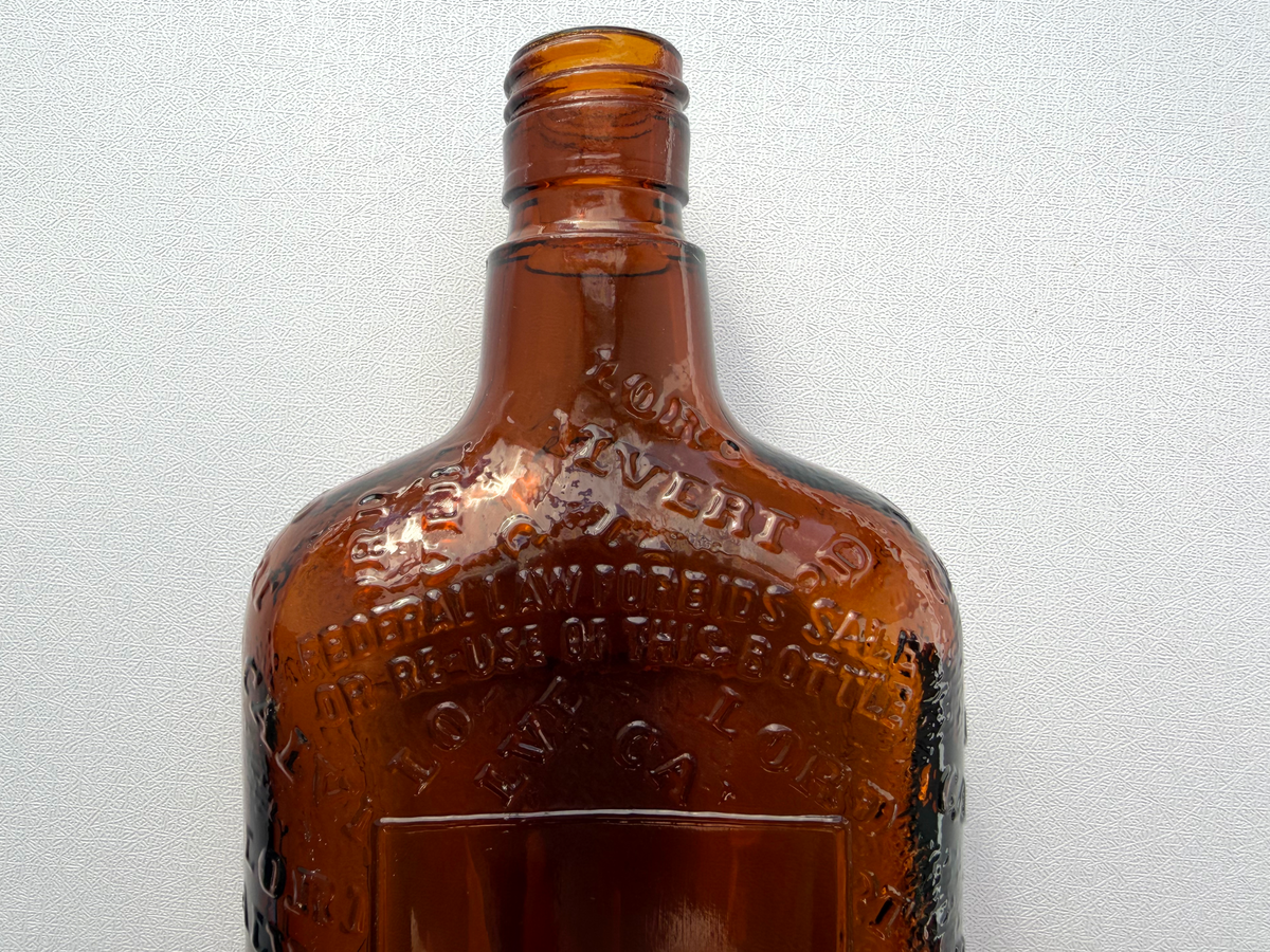 Lord Calvert Men of Distinction distillers embossing close-up, 1952 amber glass whiskey flask