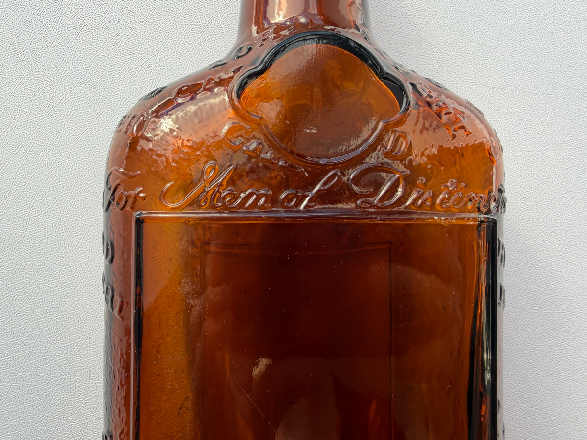 Lord Calvert 1952 amber whiskey flask One Pint embossing close-up, vintage American spirits glass collectible