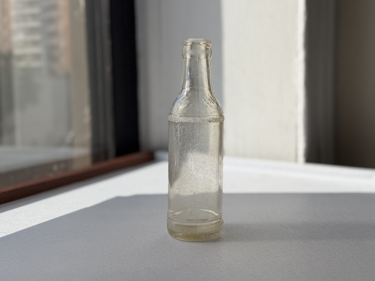 Manhattan Special soda bottle held in hand showing scale, vintage Brooklyn NYC clear glass collectible