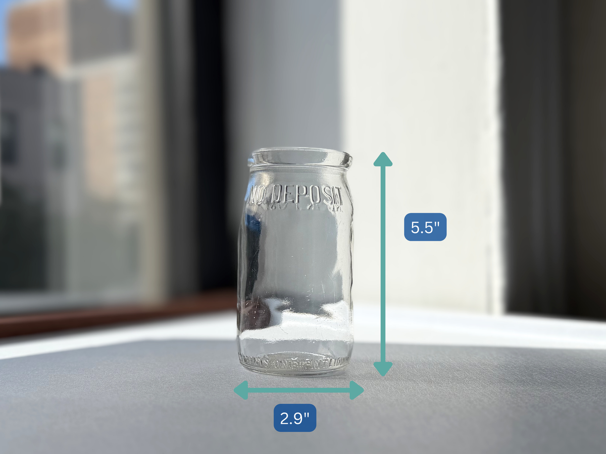 No Deposit 1954 pint milk bottle angled right view, clear embossed glass in like-new condition