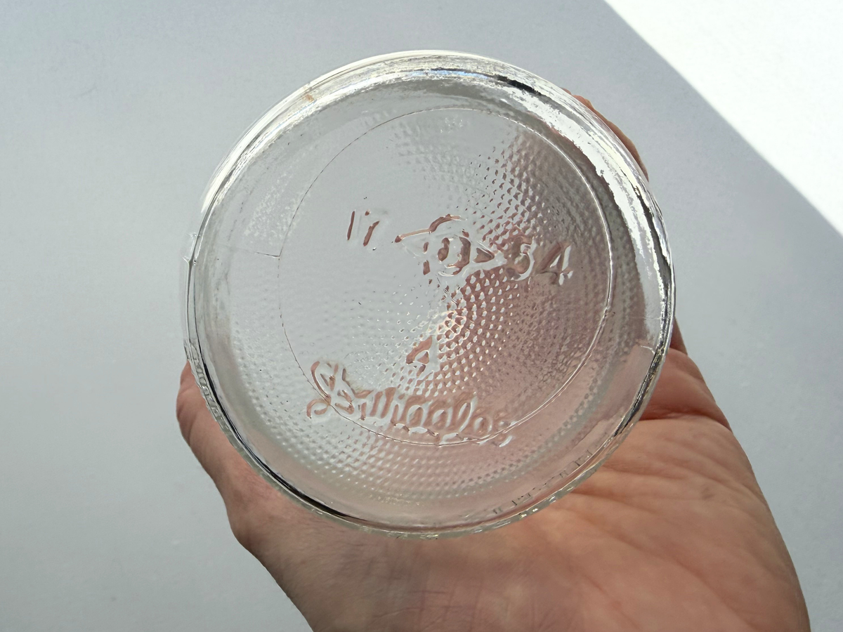No Deposit 1954 milk bottle front embossing held in hand showing scale, clear glass vintage dairy collectible