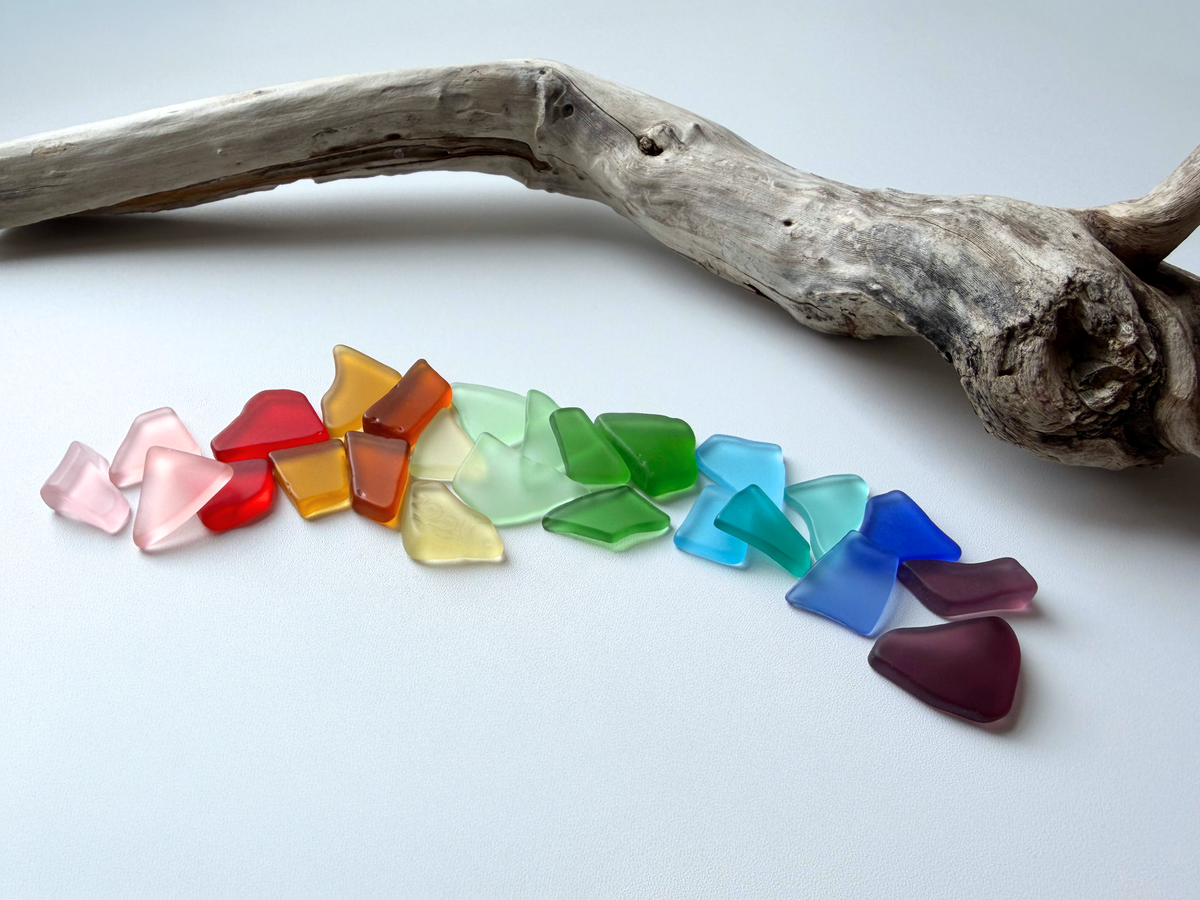 Rainbow-colored medium tumbled sea glass mix ranging 0.75 to 1.25 inches in cobalt blue, emerald green, amber, and pastel tones with smooth frosted edges, ideal for mosaic art and coastal decor.