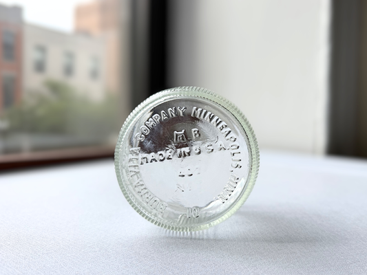 Close-up of the embossed base of a vintage Burma-Shave jar reading Burma Vita Company Minneapolis Minn Made in USA, confirming its mid-century American origin.