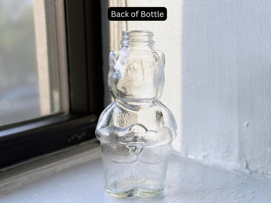 Vintage clear glass piggy bank angled view showing embossed pig form, PAT PEND marking 1950s