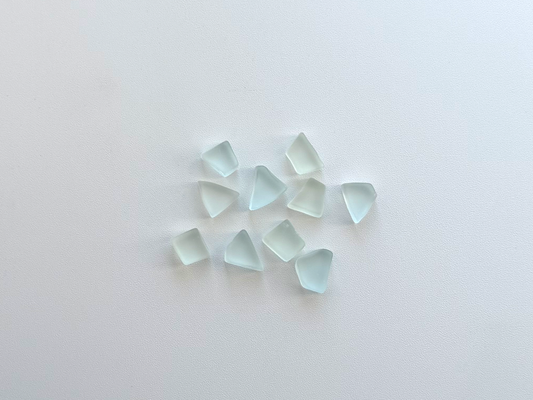 Small pile of pale seafoam and sky blue tumbled sea glass pieces, flat on two sides