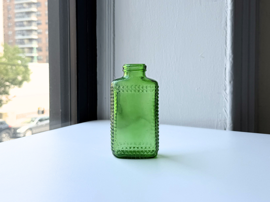 Vintage kelly green Airwick hobnail glass bottle, front view showing the studded texture