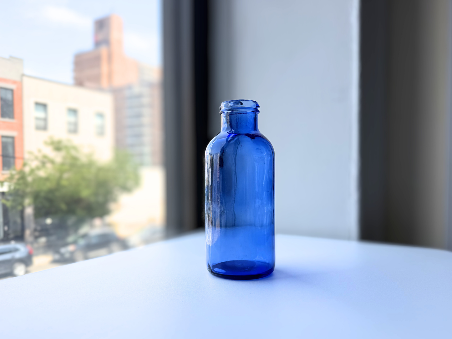 Vintage cobalt blue glass pharmaceutical bottle shown from a side angle
